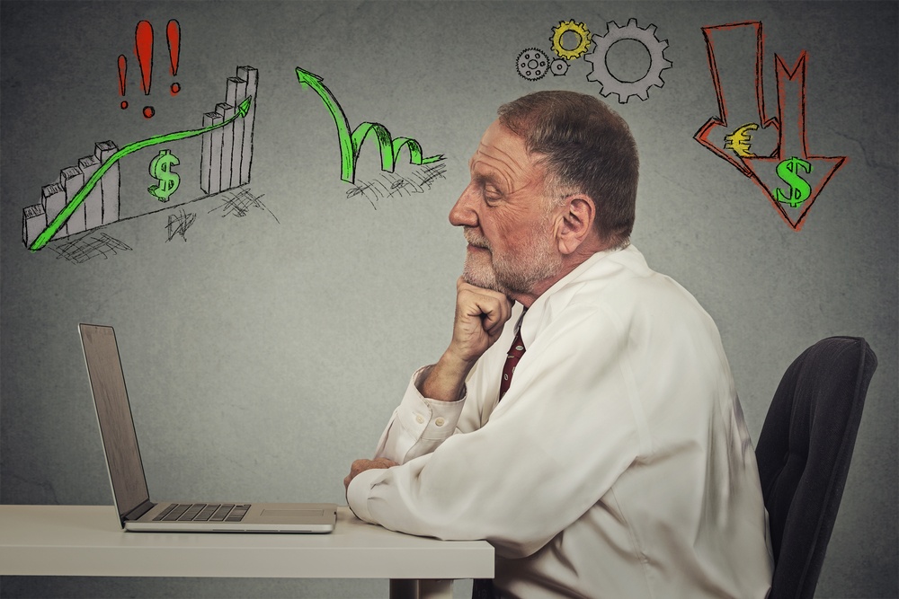 Side profile view senior business man working on computer isolated on grey wall background. Anticipation of financial crisis, bad, poor economy concept. Corporate employee thinking, making decisions.