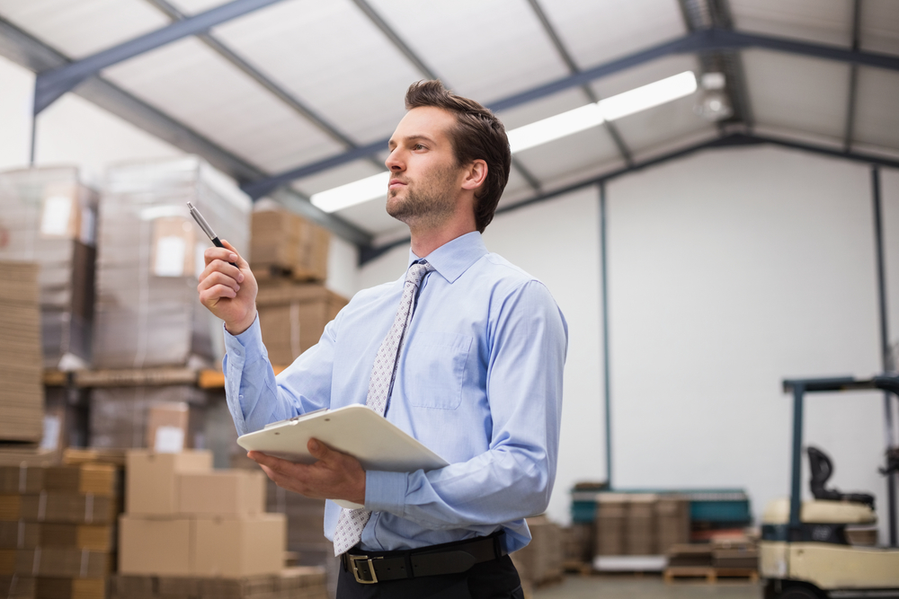 Side view of manager holding clipboard in the warehouse-1
