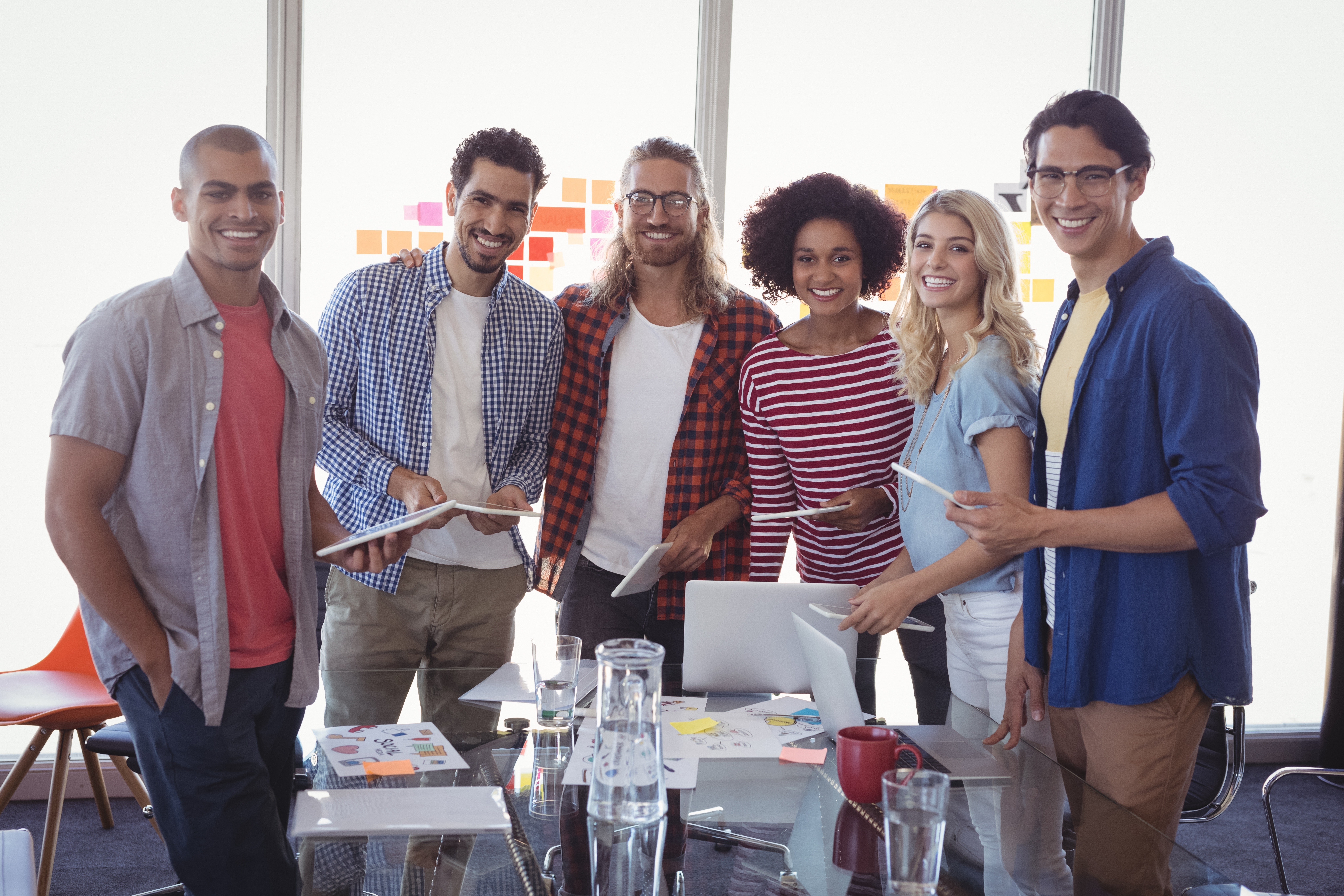 Portrait of young business team standing together at desk